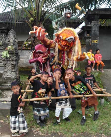 Balinese boys flick gang symbols before parading thir evil spirits around town